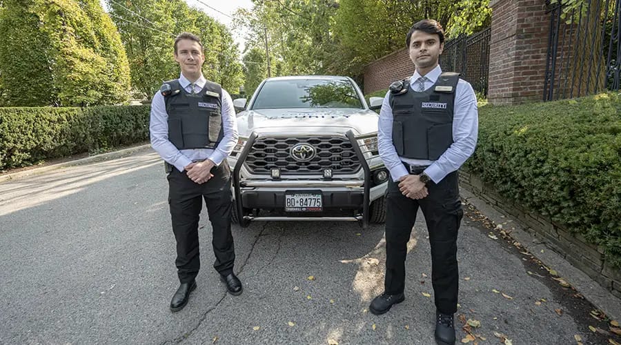 Two security guards are standing in front of a vehicle-Condor Security (Security Guard Jobs) (How To Become A Security Supervisor | NOC 6316 Guide)