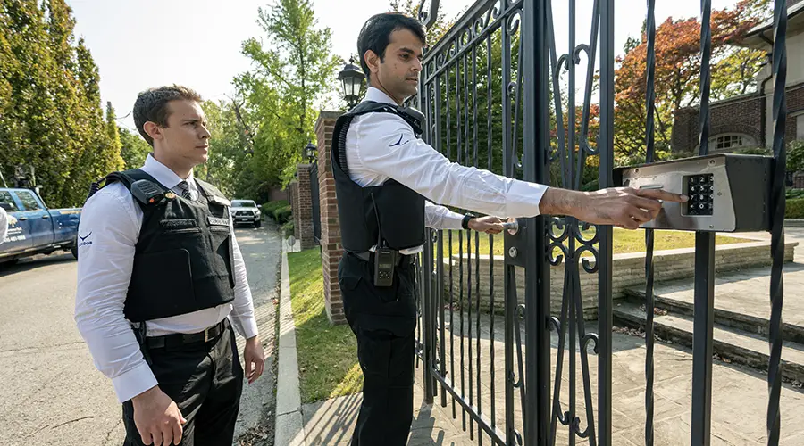 Two security guards at a gate, one using an access card-Condor Security (alarm systems) (Home Protection Programs)